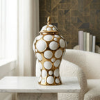 Gilded orbit jar on marble by boucle chair