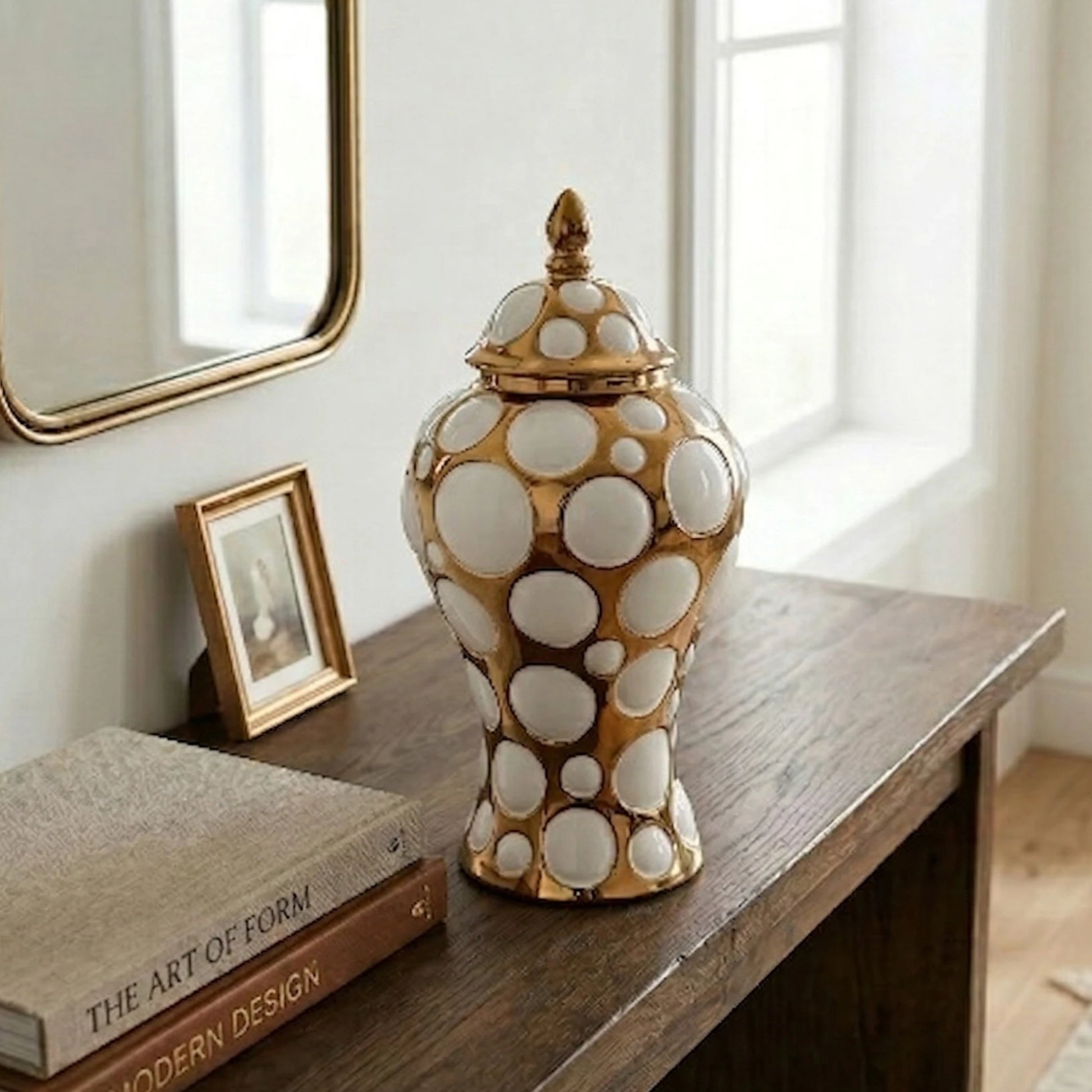 Gilded orbit jar in entry under gilt mirror