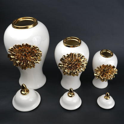 White ceramic decorative jar with gold sculpted floral design and lid