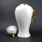 White ceramic decorative jar with gold sculpted floral design and lid