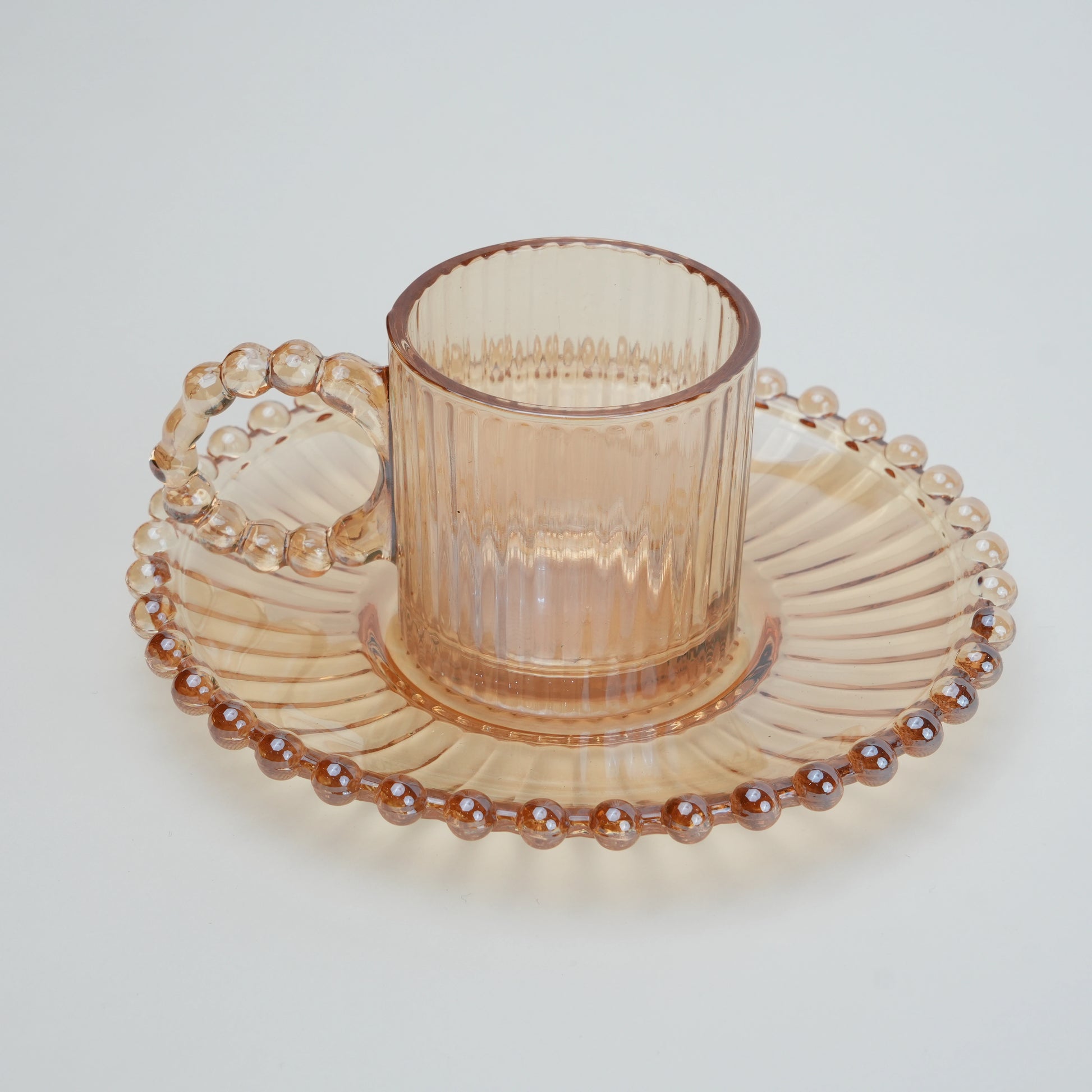 beaded glass tea cup and saucer set available in amber and clear textured glass for modern table setting