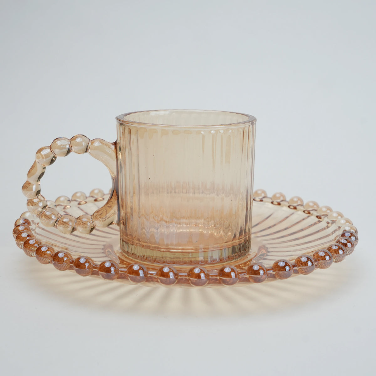 beaded glass tea cup and saucer set available in amber and clear textured glass for modern table setting