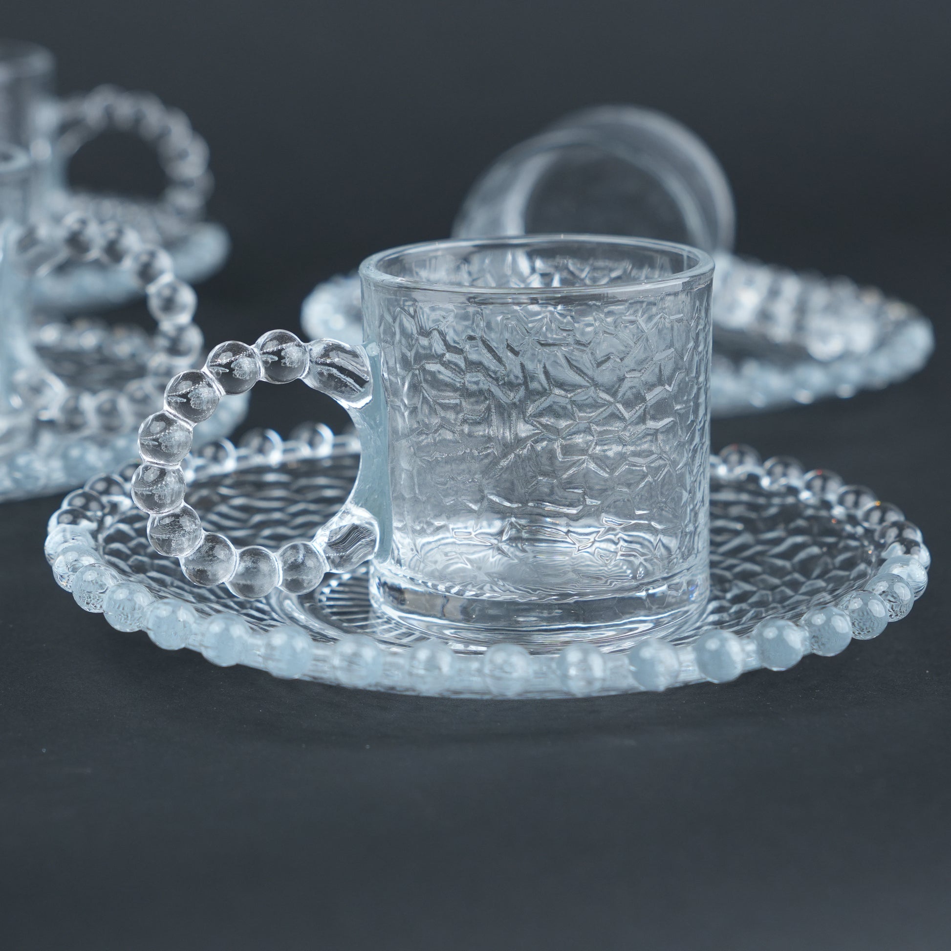 beaded glass tea cup and saucer set available in amber and clear textured glass for modern table setting