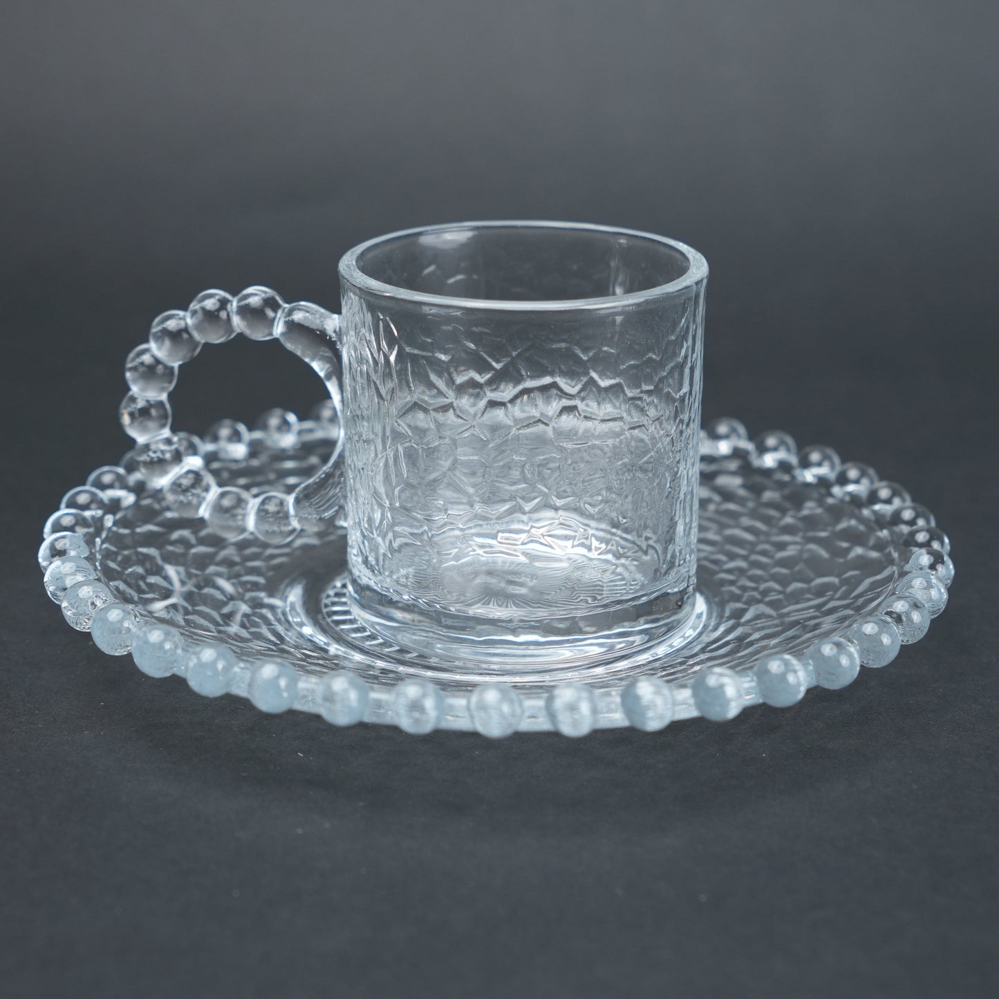 beaded glass tea cup and saucer set available in amber and clear textured glass for modern table setting