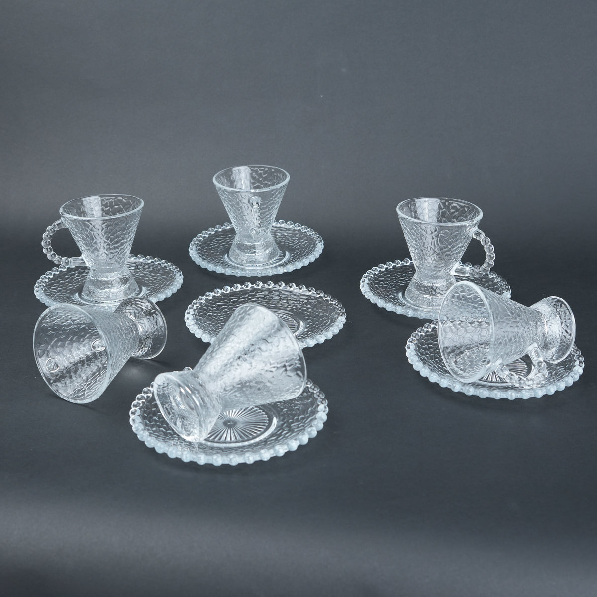 clear textured glass flared tea cup and saucer set with beaded handle for modern table setting