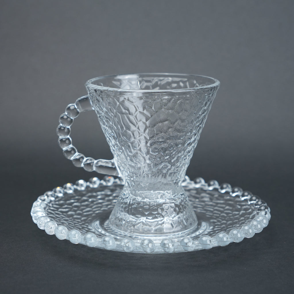 clear textured glass flared tea cup and saucer set with beaded handle for modern table setting