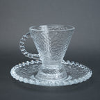clear textured glass flared tea cup and saucer set with beaded handle for modern table setting