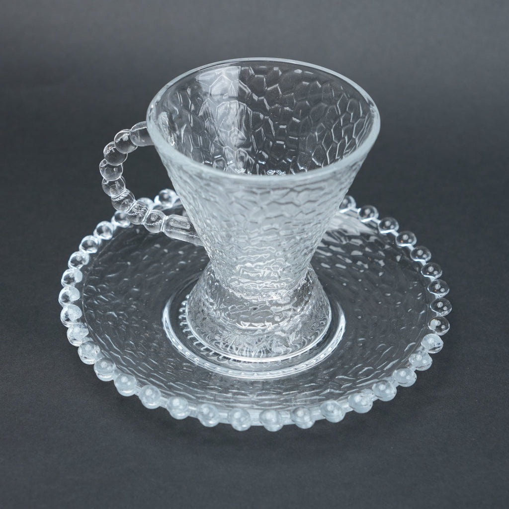 clear textured glass flared tea cup and saucer set with beaded handle for modern table setting
