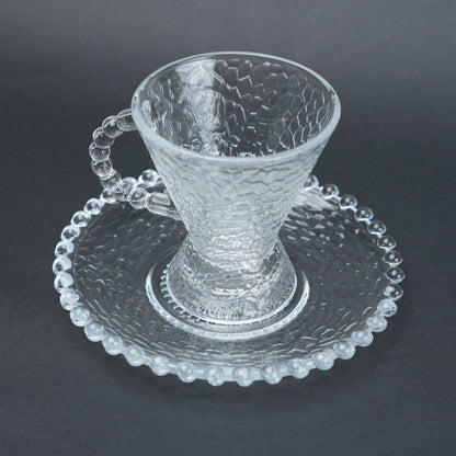 clear textured glass flared tea cup and saucer set with beaded handle for modern table setting