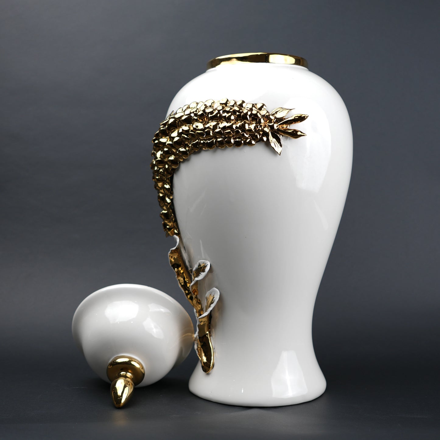 White ceramic decorative jar with gold cascading leaf design and lid