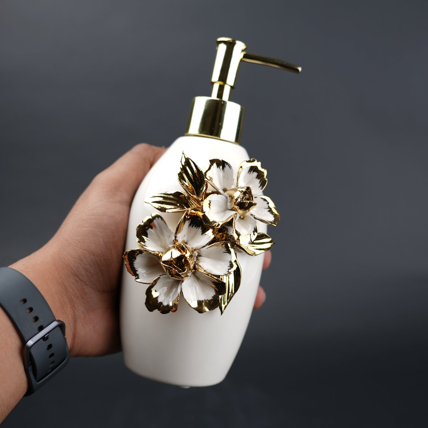 Ivory ceramic soap dispenser with gold floral detailing and metallic pump