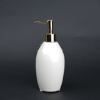 Ivory ceramic soap dispenser with gold floral detailing and metallic pump