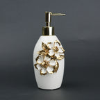 Ivory ceramic soap dispenser with gold floral detailing and metallic pump