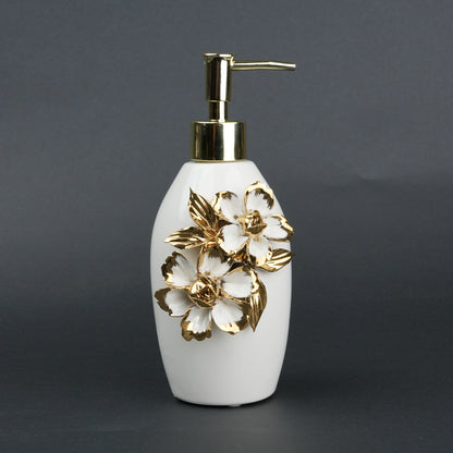 Ivory ceramic soap dispenser with gold floral detailing and metallic pump