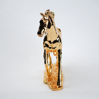 Gold horse figurine on a light gray background