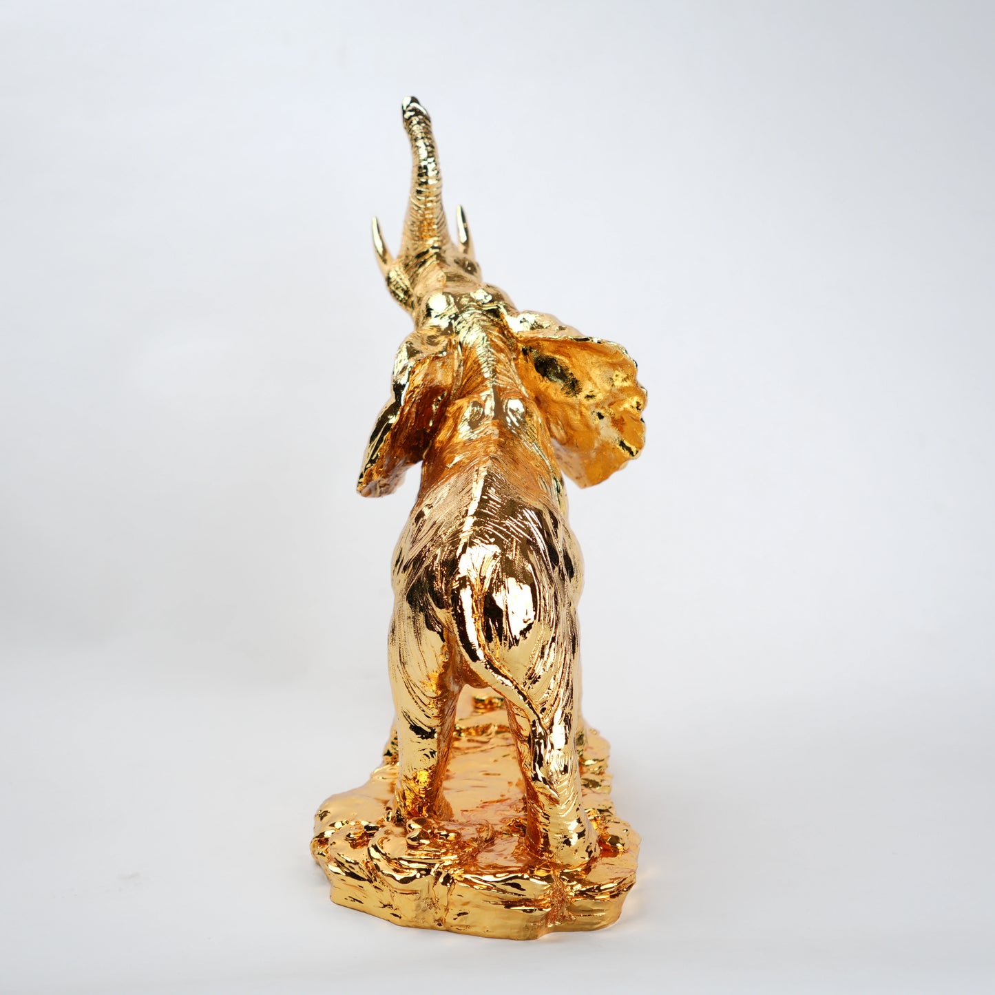Gold-colored figurine of a mythical creature on a white background