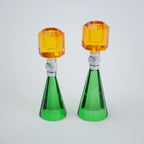 Two green and orange glass candle holders on a white background