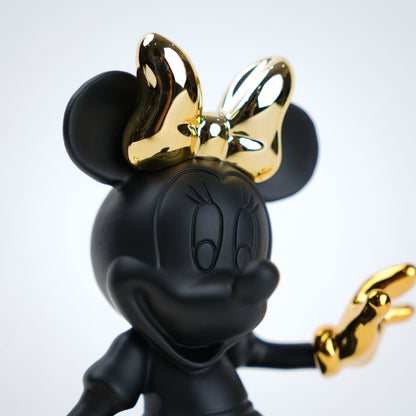Black and gold Minnie Mouse figurine with a gold bow on a white background