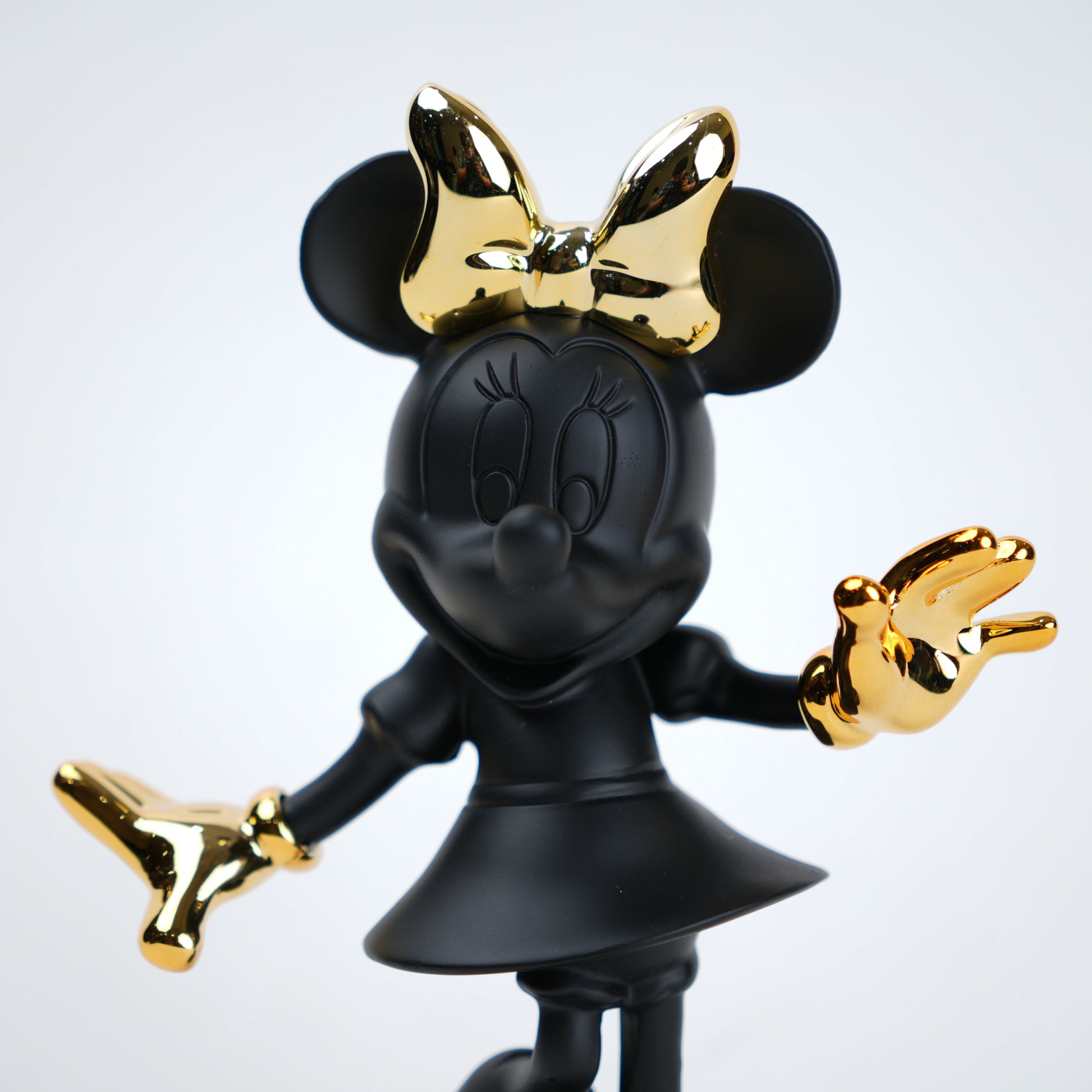 Black and gold Minnie Mouse figurine on a white background