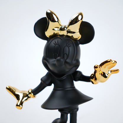 Black and gold Minnie Mouse figurine on a white background
