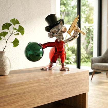 Decorative statue of a character with a green ball on a wooden surface in a room with a plant and chair.