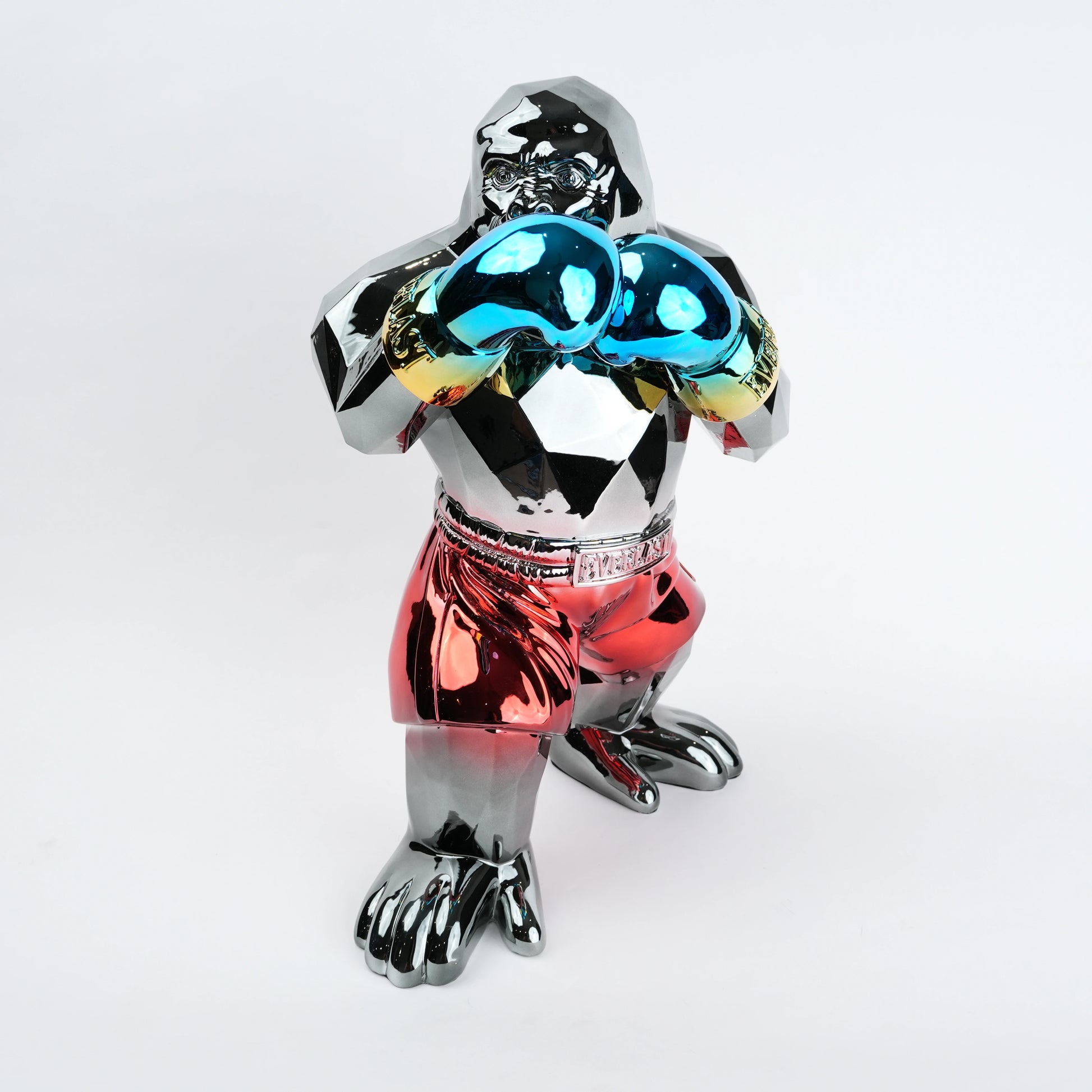 Electroplated resin gorilla boxer figurine in a strong upright stance with raised boxing gloves, featuring a reflective multicolor metallic finish, detailed muscular form, and smooth high-gloss surface designed as a bold modern decor piece.