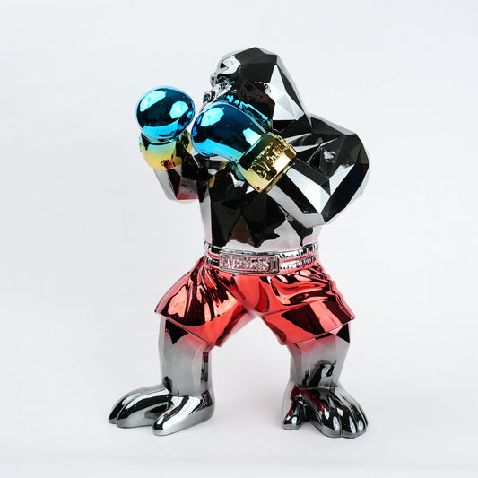 Electroplated resin gorilla boxer figurine in a strong upright stance with raised boxing gloves, featuring a reflective multicolor metallic finish, detailed muscular form, and smooth high-gloss surface designed as a bold modern decor piece.