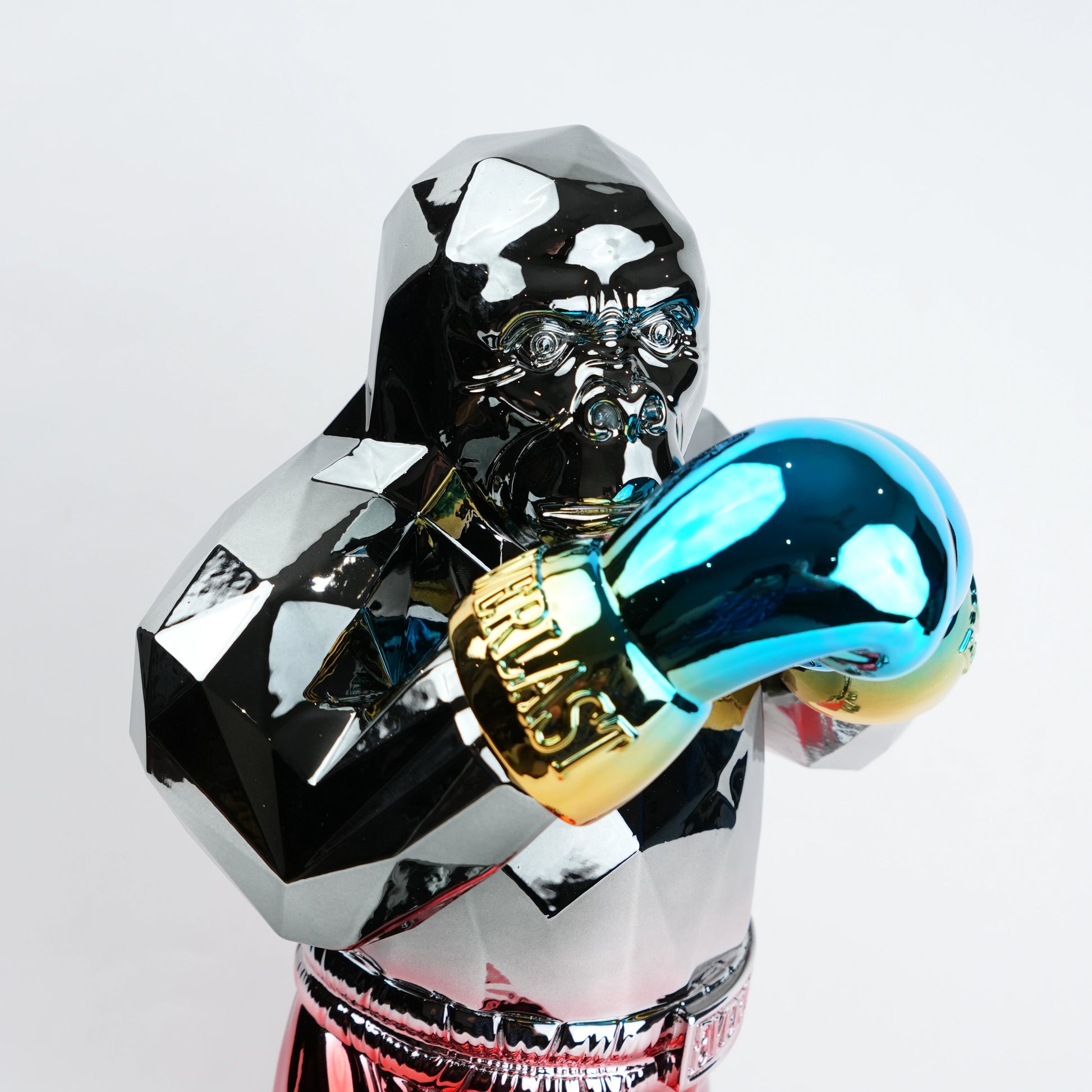 Electroplated resin gorilla boxer figurine in a strong upright stance with raised boxing gloves, featuring a reflective multicolor metallic finish, detailed muscular form, and smooth high-gloss surface designed as a bold modern decor piece.