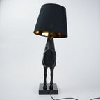 Black horse-shaped table lamp with a black shade on a white background