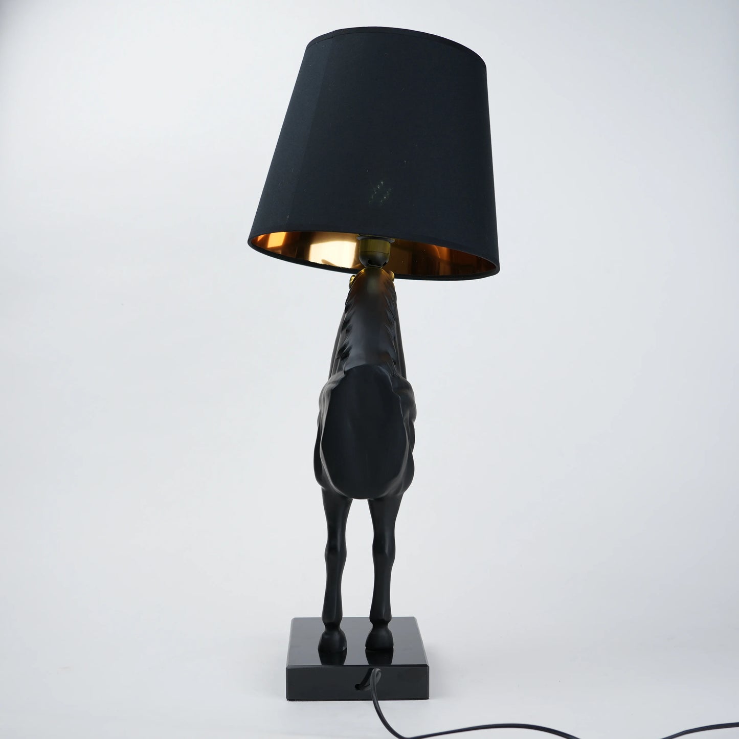 Black horse-shaped table lamp with a black shade on a white background