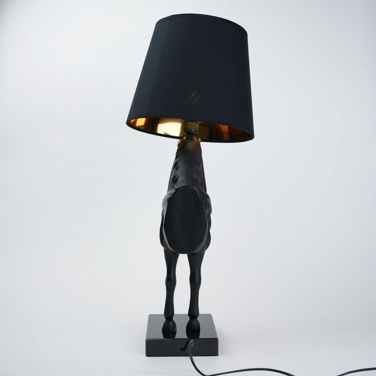 Black horse-shaped table lamp with a black shade on a white background