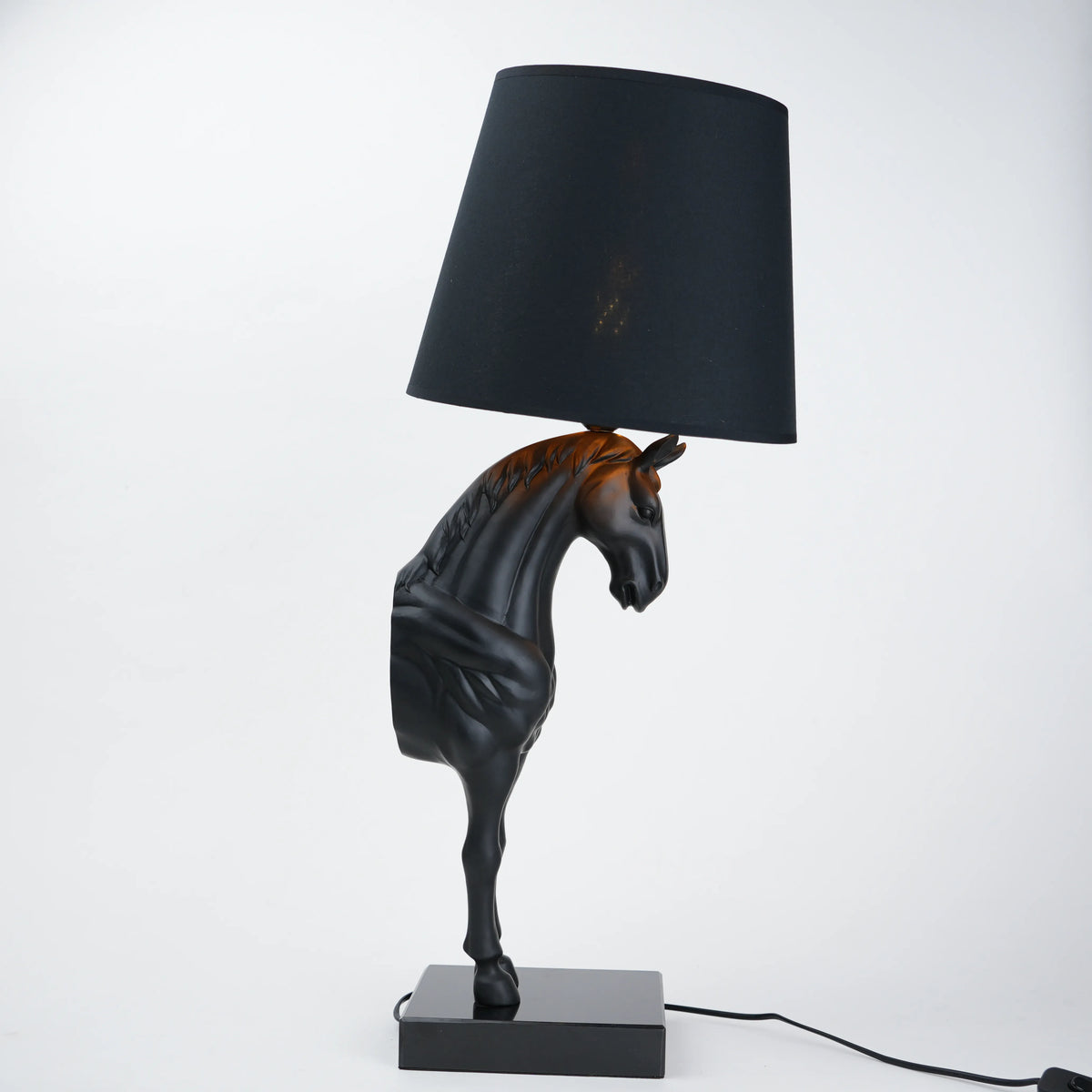 Horse-shaped table lamp with a black shade on a white background