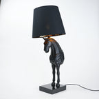 Horse table lamp featuring a detailed horse-shaped base with a premium finish, paired with a fabric lampshade that provides soft ambient lighting, designed as a decorative and functional lighting piece.