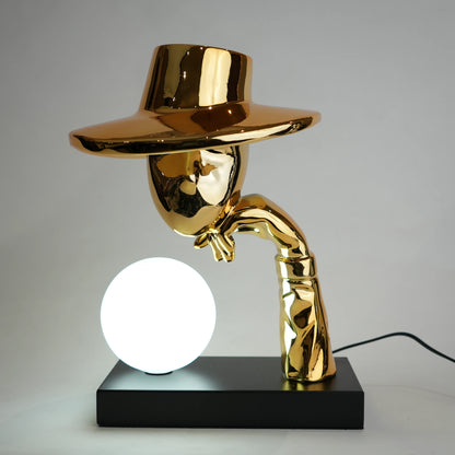 Gold-colored lamp with a spherical light bulb on a gray background