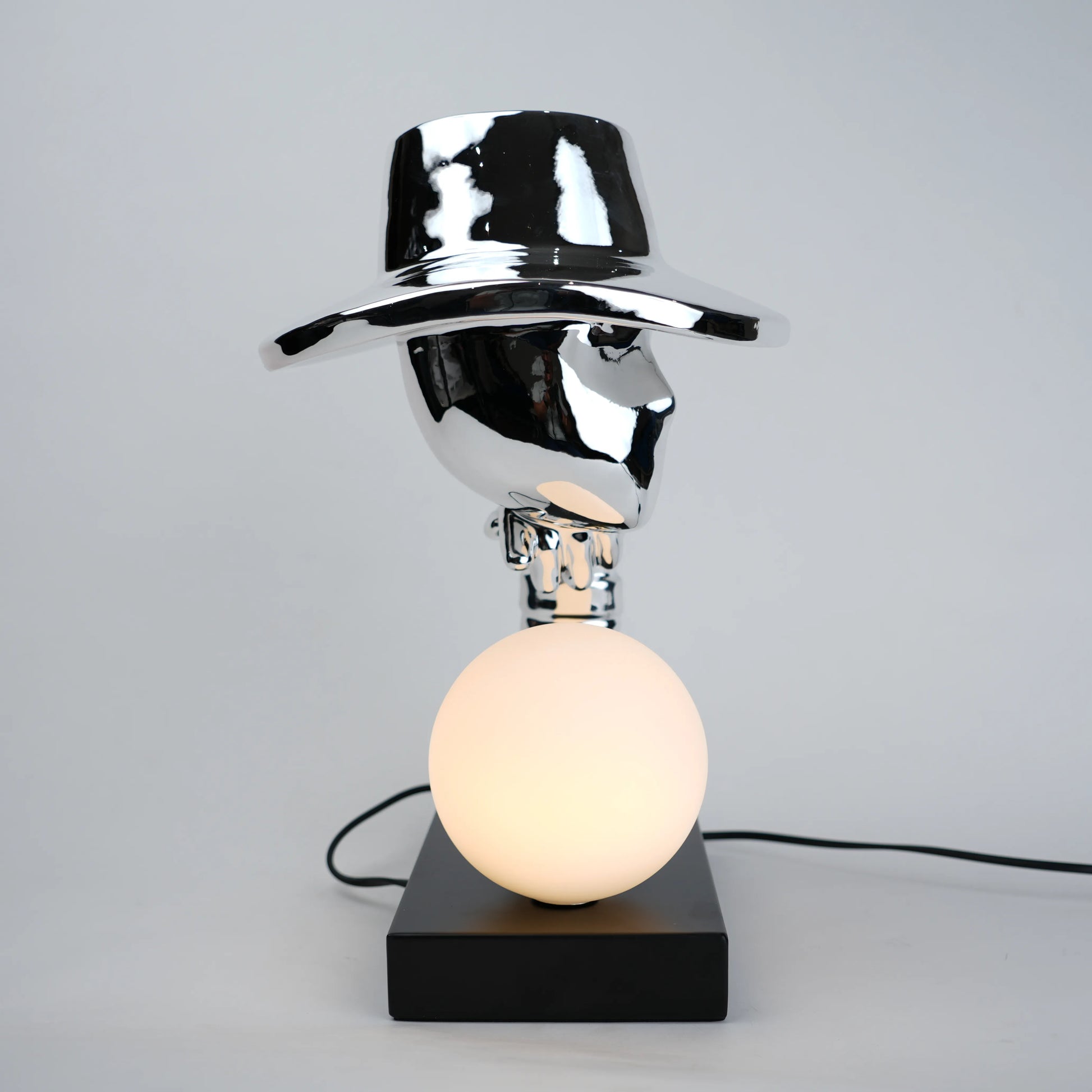 Table lamp with a metallic shade and black base on a gray background