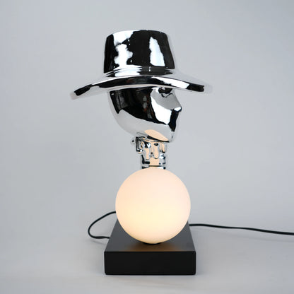 Table lamp with a metallic shade and black base on a gray background