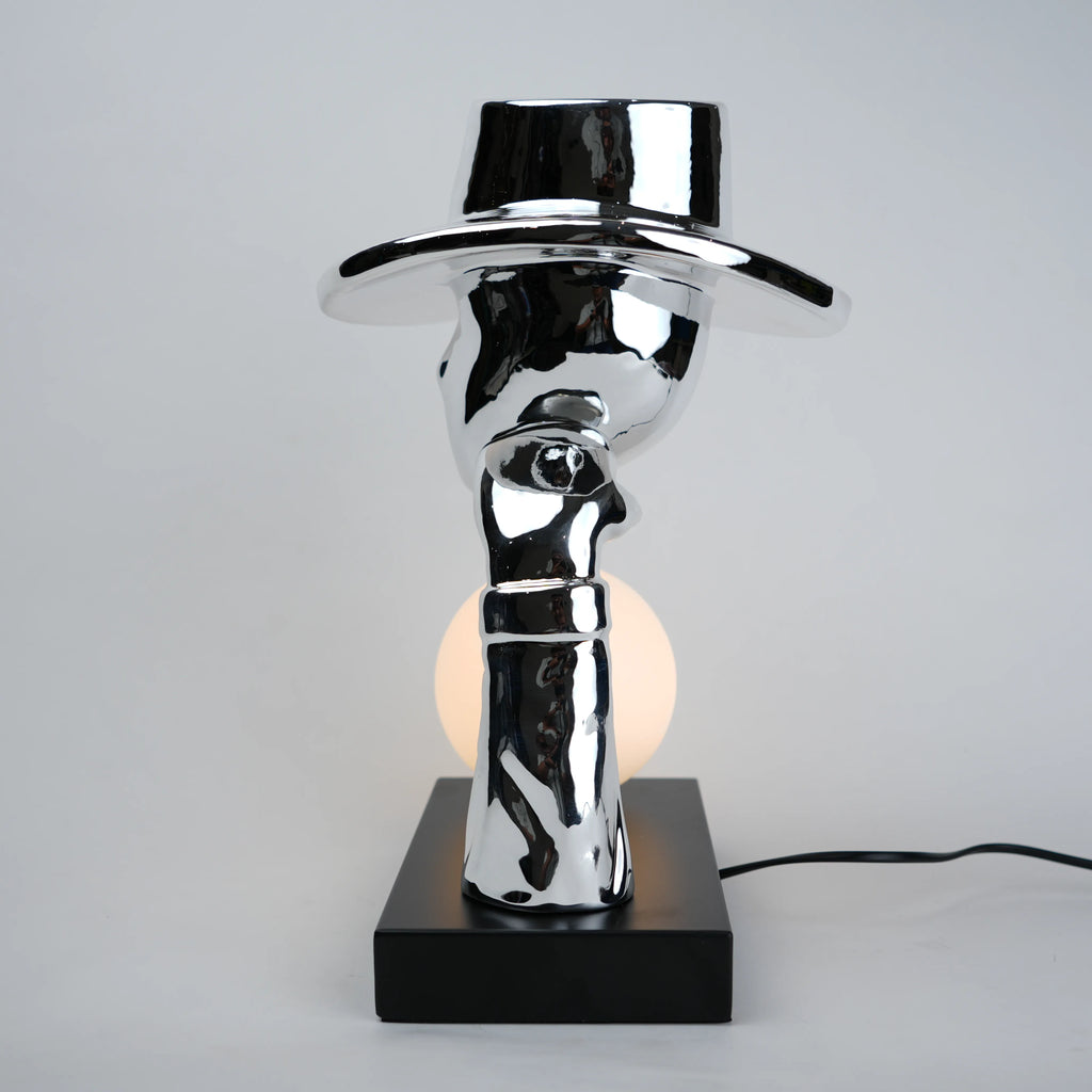 Modern table lamp with a reflective metallic design on a gray background