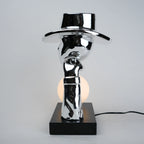 Modern table lamp with a reflective metallic design on a gray background