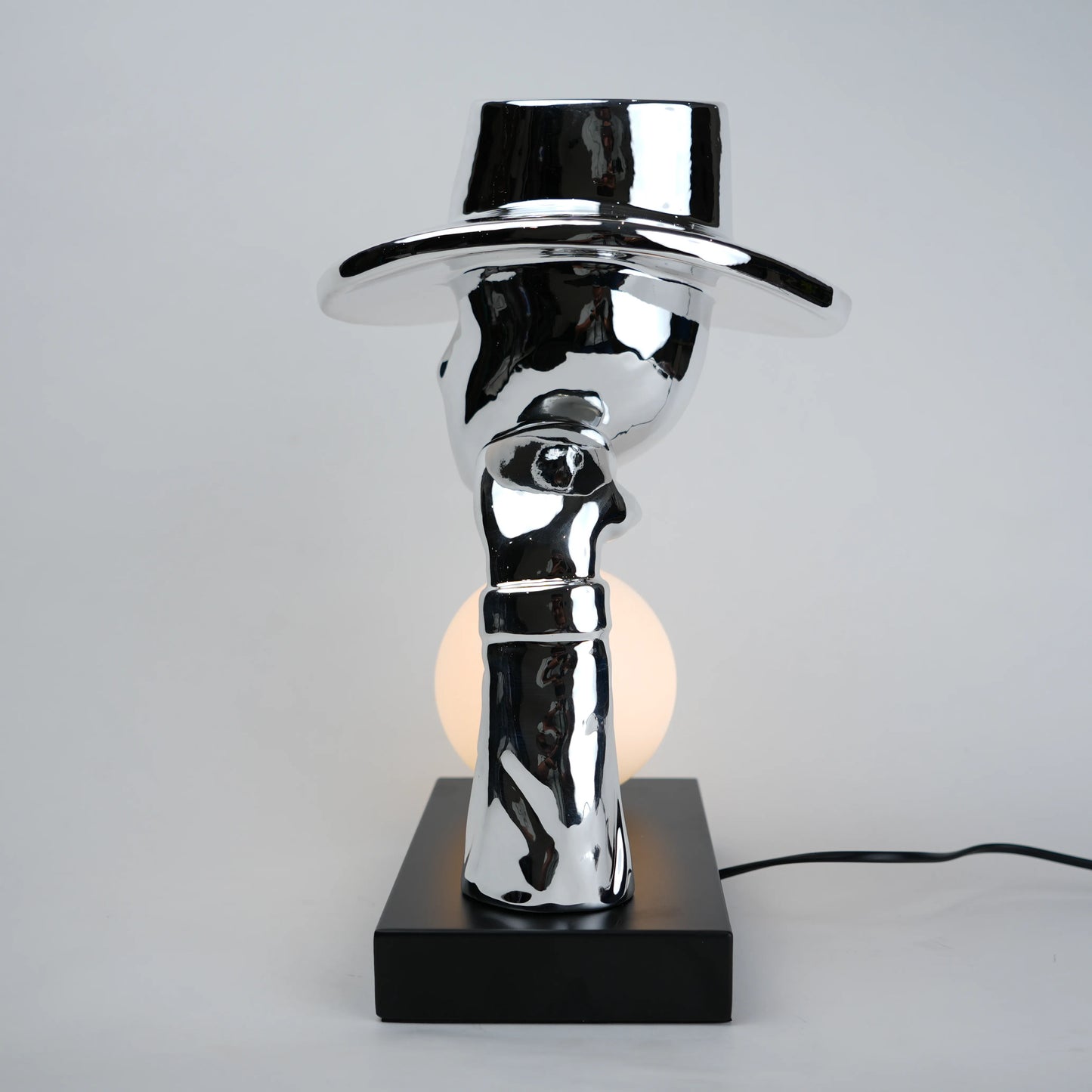 Modern table lamp with a reflective metallic design on a gray background