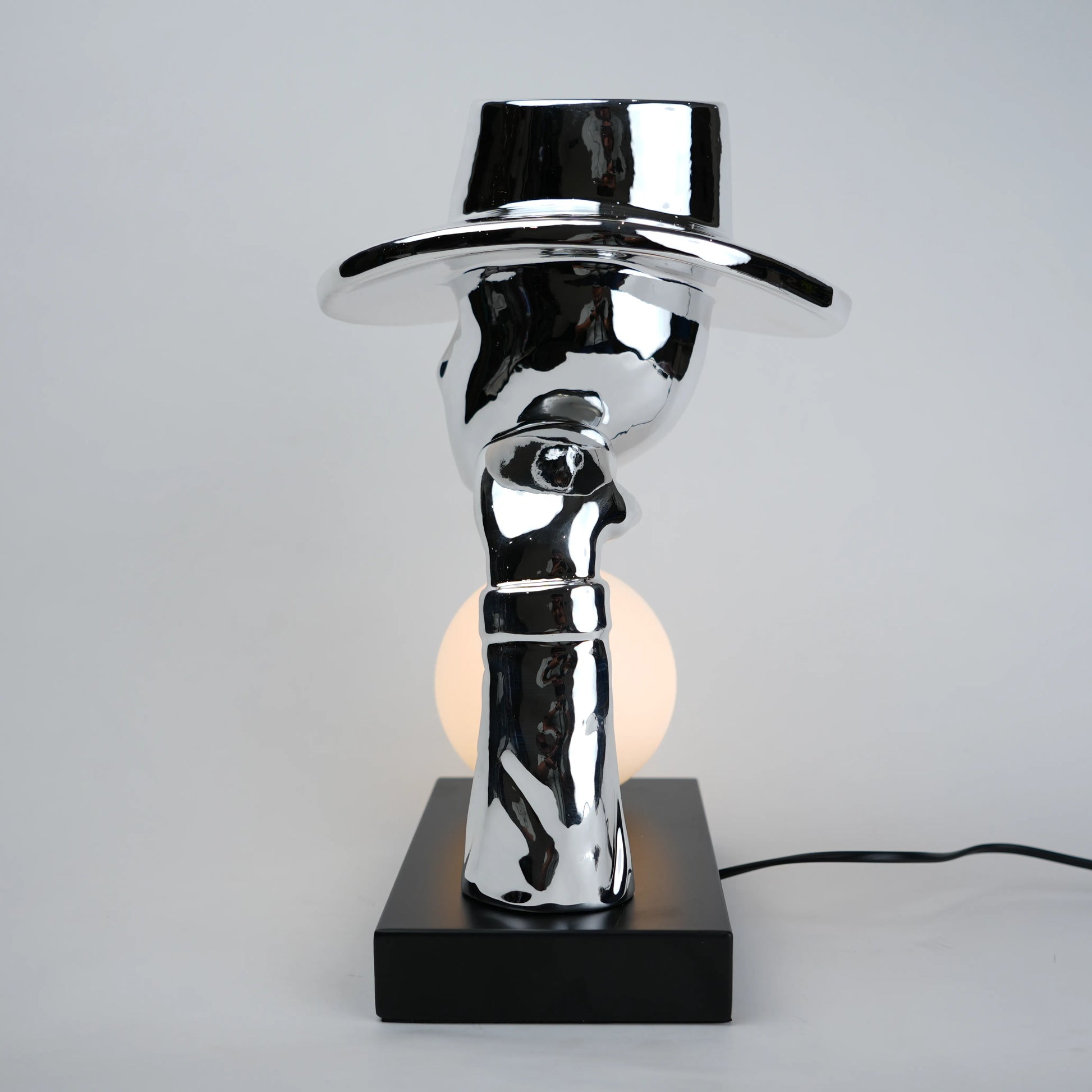 Modern table lamp with a reflective metallic design on a gray background