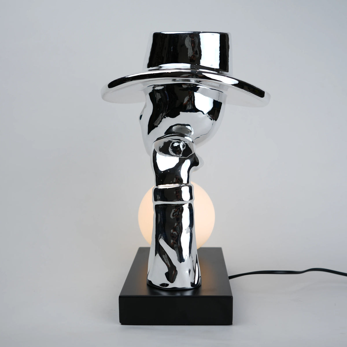 Modern table lamp with a reflective metallic design on a gray background
