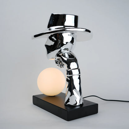 Modern table lamp with a metallic design and black base on a gray background
