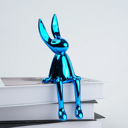 Blue metallic rabbit sculpture on a white surface