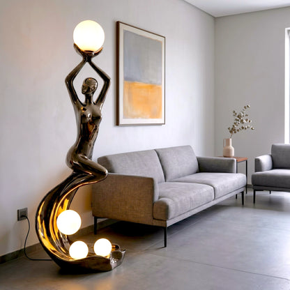 black sculptural floor lamp with human figure and orb lights
