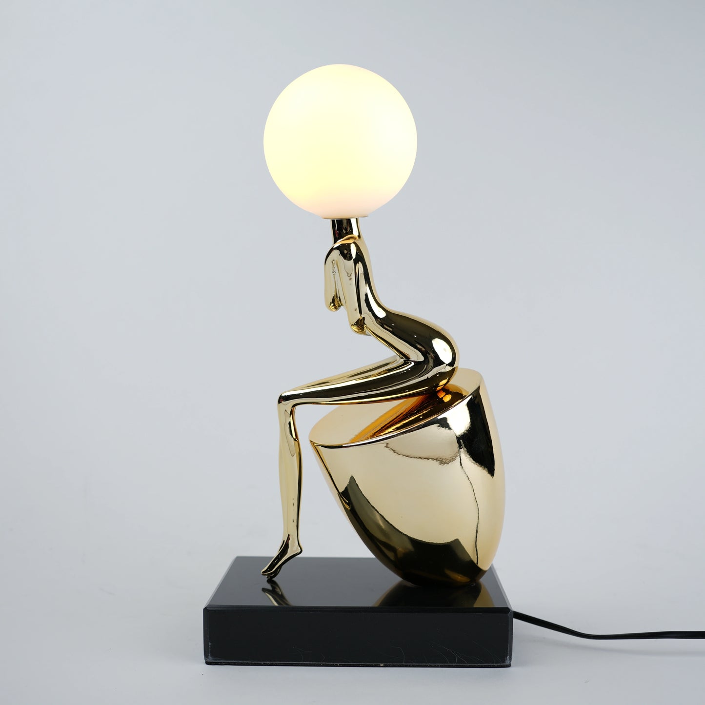 gold figure table lamp with orb light modern decor