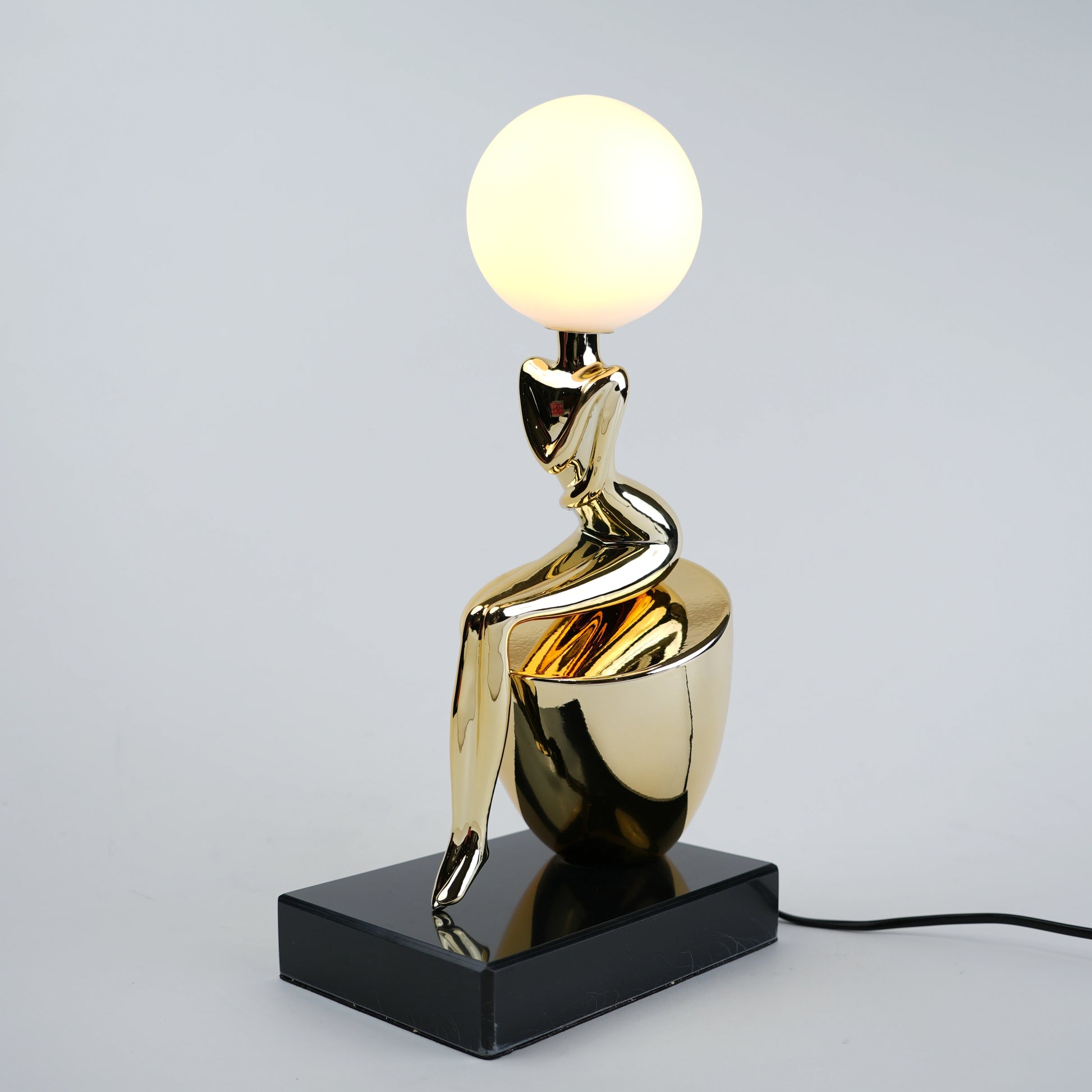 gold figure table lamp with orb light modern decor