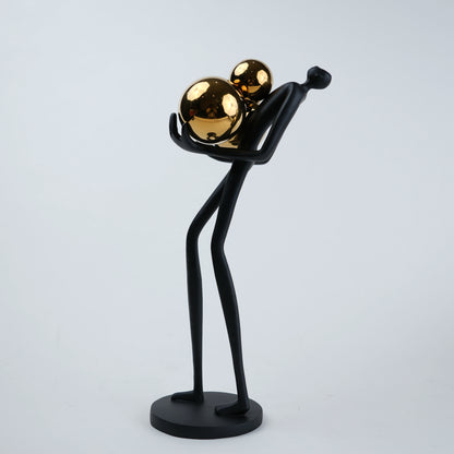 matte black figurine holding gold spheres modern decor