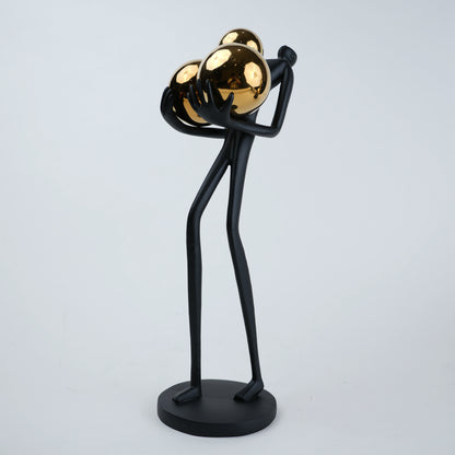matte black figurine holding gold spheres modern decor