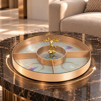 A circular copper-toned metal tray or dish featuring a printed illustration of a green tree with purple and yellow leaves on a pale gray background, surrounded by a scalloped gold border.