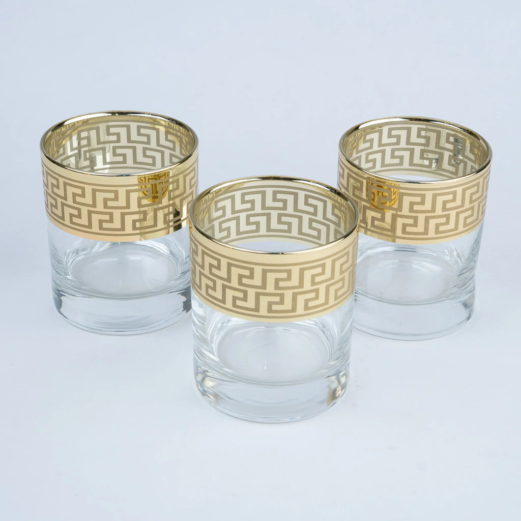 Three clear glass tumblers with gold Greek key pattern bands